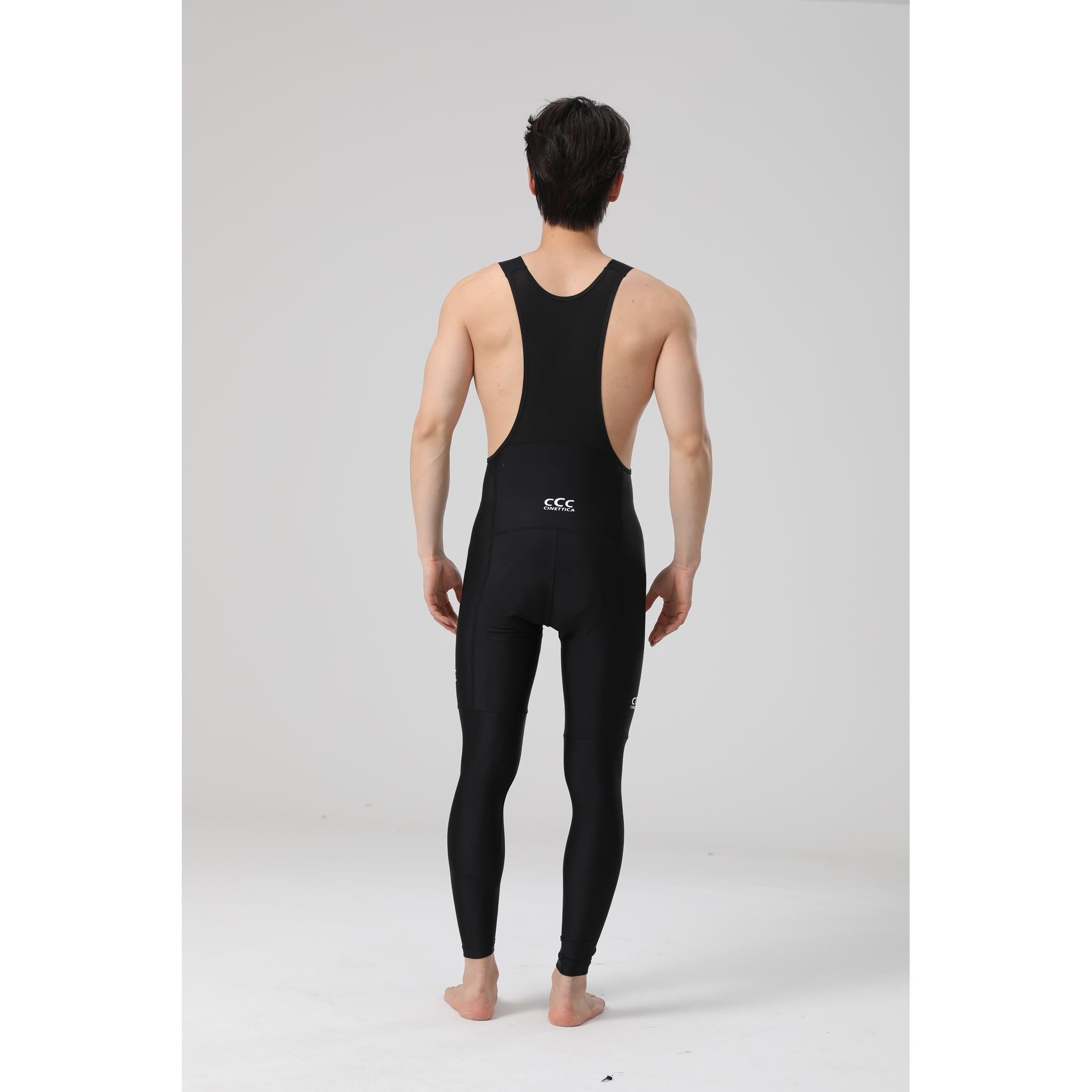 Rear view of a man wearing black Cinettica Ariston long bibknicks with white logos.