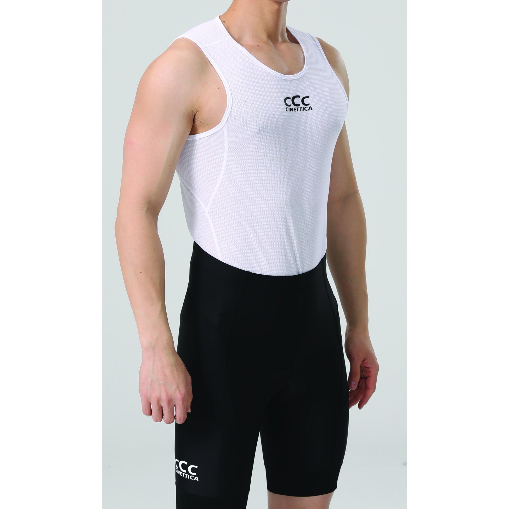 Man wearing a white Cinettica lightweight baselayer tank top with black cycling shorts.